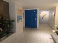 a hallway with a blue door and a tile floor at Résidence arc en ciel, proche de la plage accés direct ,internet et parking privatif gratuit in La Grande Motte