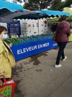 a woman standing in front of a vendor stand at a market at Résidence arc en ciel, proche de la plage accés direct ,internet et parking privatif gratuit in La Grande Motte