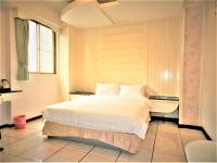 a bedroom with a large white bed and a window at @ Tainan Inn in Tainan