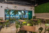 Un restaurante con mesas y sillas y vista al mar. en Hotel Villa Varadero, en Nuevo Vallarta 