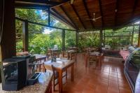 リベリアにあるRinconcito Lodgeのテーブルと椅子とテレビがあるレストラン