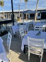 een rij witte tafels en stoelen met palmbomen bij Las Palmas Hotel - Cerritos Beach in El Pescadero
