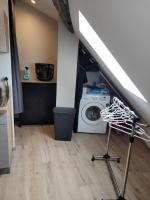 a laundry room with a washing machine and a staircase at Studio au centre-ville in Saint-Jean-de-Losne