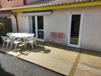 a wooden deck with a table and chairs on a house at Pavillon, de 4 à 7 couchages, dans une superbe résidence avec piscine in Soustons