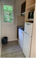 a kitchen with a white refrigerator and a window at Pavillon, de 4 à 7 couchages, dans une superbe résidence avec piscine in Soustons