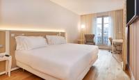 a large white bed in a room with a window at NH Collection Marseille in Marseille