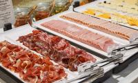 a selection of meats and cheese on display in a store at NH Collection Marseille in Marseille