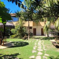 a walkway in front of a building with palm trees at Pousada Casa do Catavento in Búzios