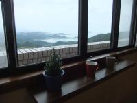 a window sill with a potted plant and two cups at Jiufen Hui Ming Homestay in Jiufen