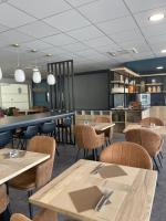 Un restaurante con mesas y sillas y un mostrador. en Campanile Montpellier Ouest - Croix D'Argent, en Montpellier