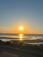 a sunset on the beach with people on the beach at Kaly in Audinghen