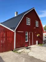 a red barn with a red door at Vesterålen Rorbuer in Bø i Vesterålen