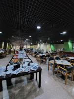 a dining room with tables and chairs and a buffet at Taj Mahal Hotel in Manaus