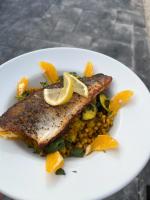 een wit bord met vis en maïs met schijfjes citroen bij Picton-House in St Clears