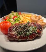 een bord met vlees en een salade en frietjes bij Picton-House in St Clears