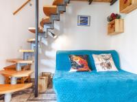 a room with a blue couch and a spiral staircase at Studio Rond Point des Pistes-19 by Interhome in Tignes