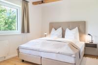 - une chambre avec un grand lit blanc et une fenêtre dans l&#39;établissement Apartment Eden Großbichl, 