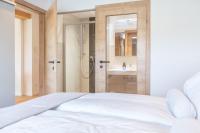 - une chambre avec un lit blanc et une douche dans l&#39;établissement Apartment Eden Großbichl, 