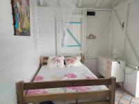 Tempat tidur dalam kamar di la villa carib&eacute;enne de la plage des surfeurs