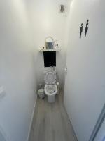 a bathroom with a toilet with a shelf on the wall at Appartement Charmant Cocon Plus in Croix
