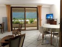 a living room with a table and chairs and a balcony at 2P 4* 58m2 face au Lac in Aix-les-Bains