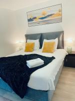 1 cama grande con manta negra y almohadas amarillas en Hotel L&#39;Empire, en Olm