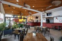 Un restaurante con techos de madera y mesas y sillas. en Divers Paradise Boutique Hotel, en Bocas Town