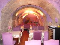 een restaurant met paarse tafels en stoelen in een tunnel bij Los Calaos de Briones in Briones