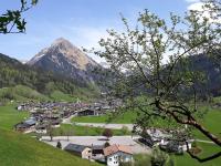a small town in a valley with a mountain at Fernblick Frühstückspension in Schoppernau