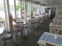a restaurant with tables and chairs and windows at Strandhaus Edersee Nr 12 - Kaminzimmer, Seeblick, Badestrand, Seeterrasse in Waldeck