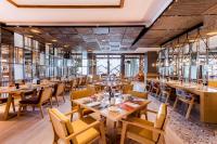 a restaurant with wooden tables and chairs at Crowne Plaza Vientiane by IHG in Vientiane