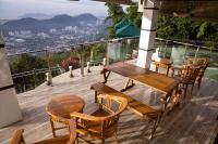 a wooden deck with tables and chairs on a balcony at Hickory Penang Hill in George Town