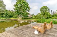 a table with a vase and chairs next to a pond at Raesborre in Leuven