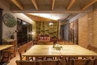 a room with a large wooden table and a clock at Muho B&amp;B in Dongshan