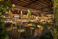um restaurante com mesas de madeira e cadeiras verdes em Valamar Amicor Resort em Stari Grad