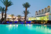 einem großen Pool vor einem Gebäude mit Palmen in der Unterkunft Leonardo Privilege Eilat Hotel - All inclusive in Eilat