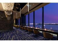 Un comedor largo con una mesa larga y sillas. en Villa Fontaine Premier Haneda Airport, en Tokio