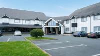 Un edificio con coches aparcados en un estacionamiento. en Aberystwyth Park Lodge Hotel, en Aberystwyth