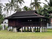 ein Haus auf Stelzen mit Palmen im Hintergrund in der Unterkunft Red Coral Cottage in Tanjung Rhu