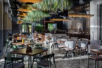 a restaurant with tables and chairs and plants at ARCA Resort 