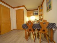 a kitchen with wooden chairs and a counter top at Appartement Les Menuires, 2 pièces, 4 personnes - FR-1-452-253 in Les Menuires