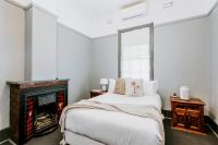 Un dormitorio con una cama y una chimenea. en Federal Hotel Mudgee, en Mudgee