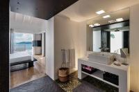 a bathroom with a sink and a large mirror at Infiniti Entire Luxury Villa Breath Taking View in St Barth in Pointe Milou