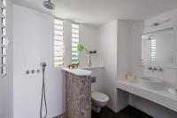 a white bathroom with a toilet and a sink at Infiniti Entire Luxury Villa Breath Taking View in St Barth in Pointe Milou