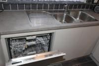 a kitchen with a sink and a dish rack in an oven at Orchidee in Comines