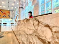 a person standing in a building with a marble wall at Uni-Resort Ku-Kuan in Heping