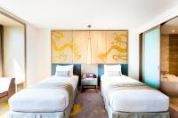 two beds in a room with a sink at Crowne Plaza Vientiane by IHG in Vientiane