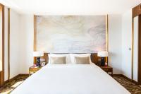 a bedroom with a white bed and a painting on the wall at Crowne Plaza Vientiane by IHG in Vientiane