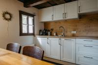 a kitchen with white cabinets and a wooden table at Kellerstöckl Berg 106 in Strem