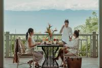 攀瓦海滩Amatara Welleisure Resort的一群人坐在甲板上的桌子旁